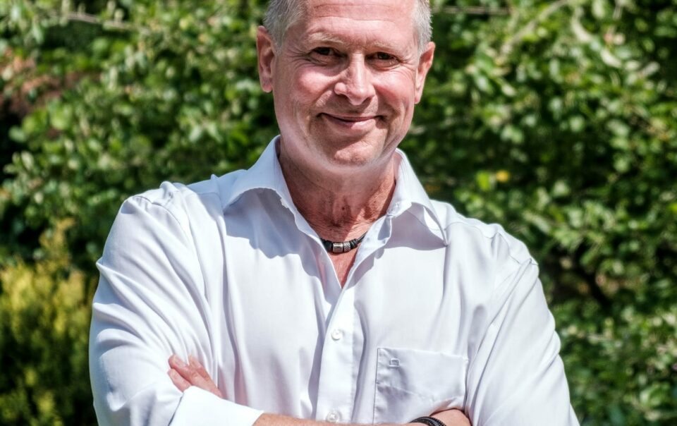 Weltrekordhalter Stegreifreden Ike Fast - Cool mit gekreuzten Armen vor natürlicher Kulisse.